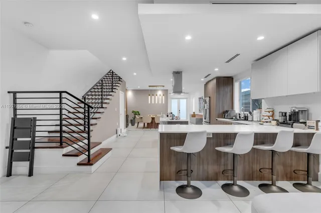 a kitchen with a dining table chairs and view of living room