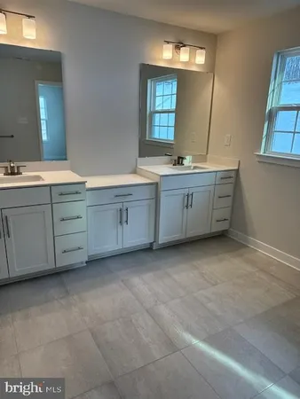 a spacious bathroom with double sink and a mirror