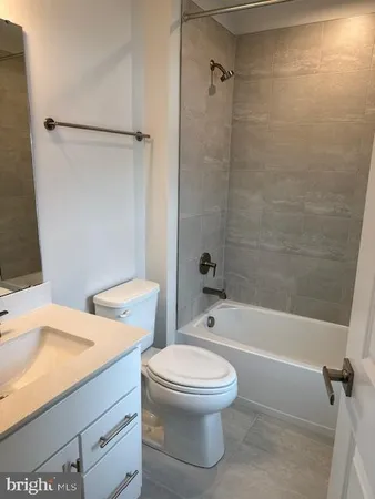 a white toilet sitting next to a bath tub and a shower