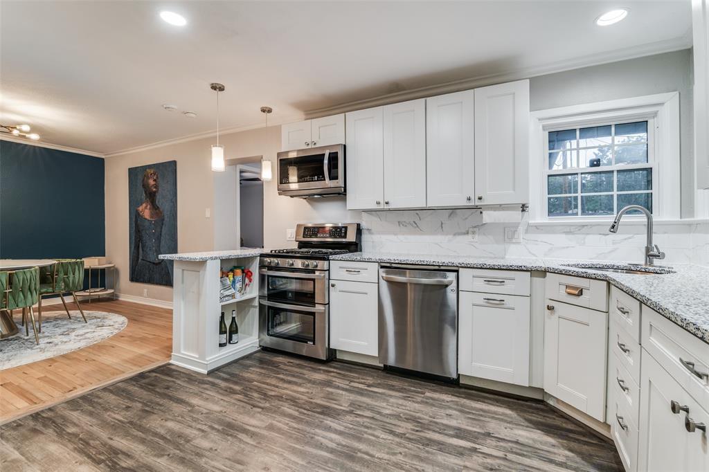 3714 Valley Ridge Road Dallas, TX 75220 - Photo 10 of 26 a kitchen with stainless steel appliances granite countertop a stove a sink and white cabinets