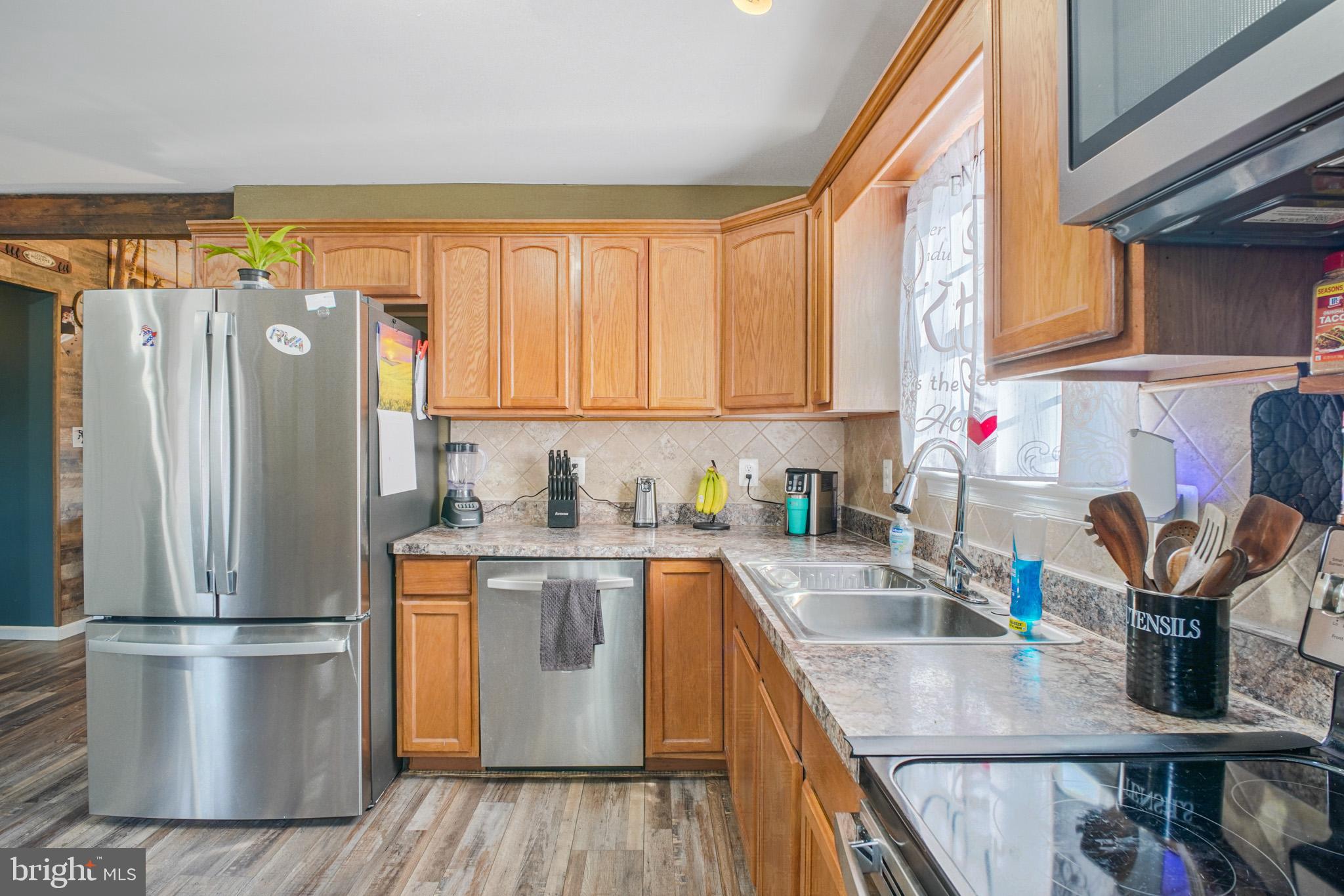 12254 Birkdale Road Ruther Glen, VA 22546 - Photo 11 of 68 a kitchen with stainless steel appliances a refrigerator a sink a stove and cabinets