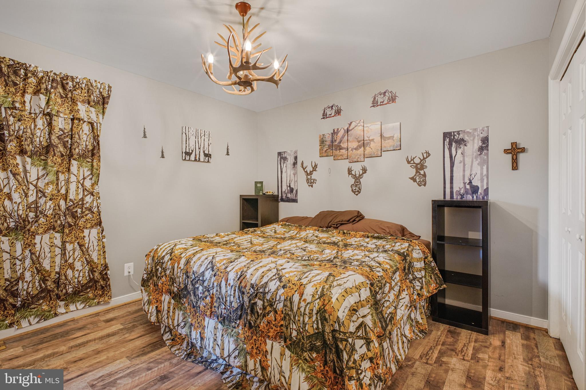 12254 Birkdale Road Ruther Glen, VA 22546 - Photo 15 of 68 a bedroom with a bed and a chandelier