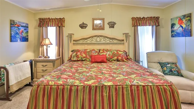 a bedroom with a bed a painting on the wall and a window