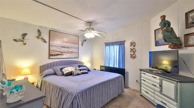 a bedroom with a bed and a flat tv screen on dresser