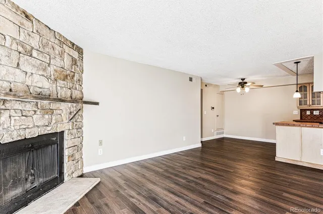 a view of a kitchen with wooden floor and a fireplace