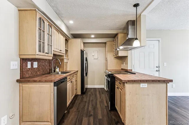 a kitchen with stainless steel appliances granite countertop a stove and a refrigerator