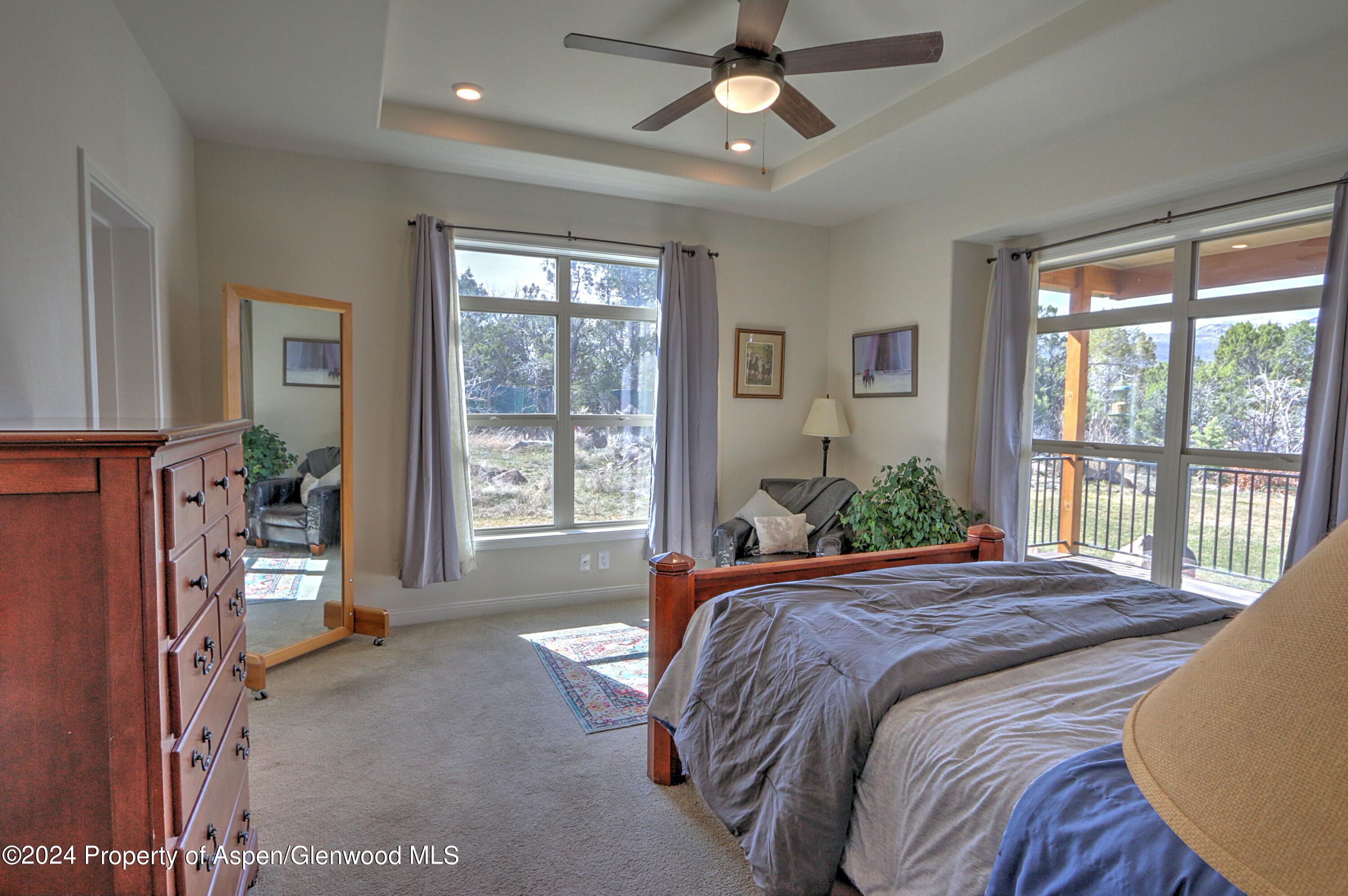 227 Lava Drive El Jebel, CO 81621 - Photo 17 of 38 a bedroom with a large bed and a large window