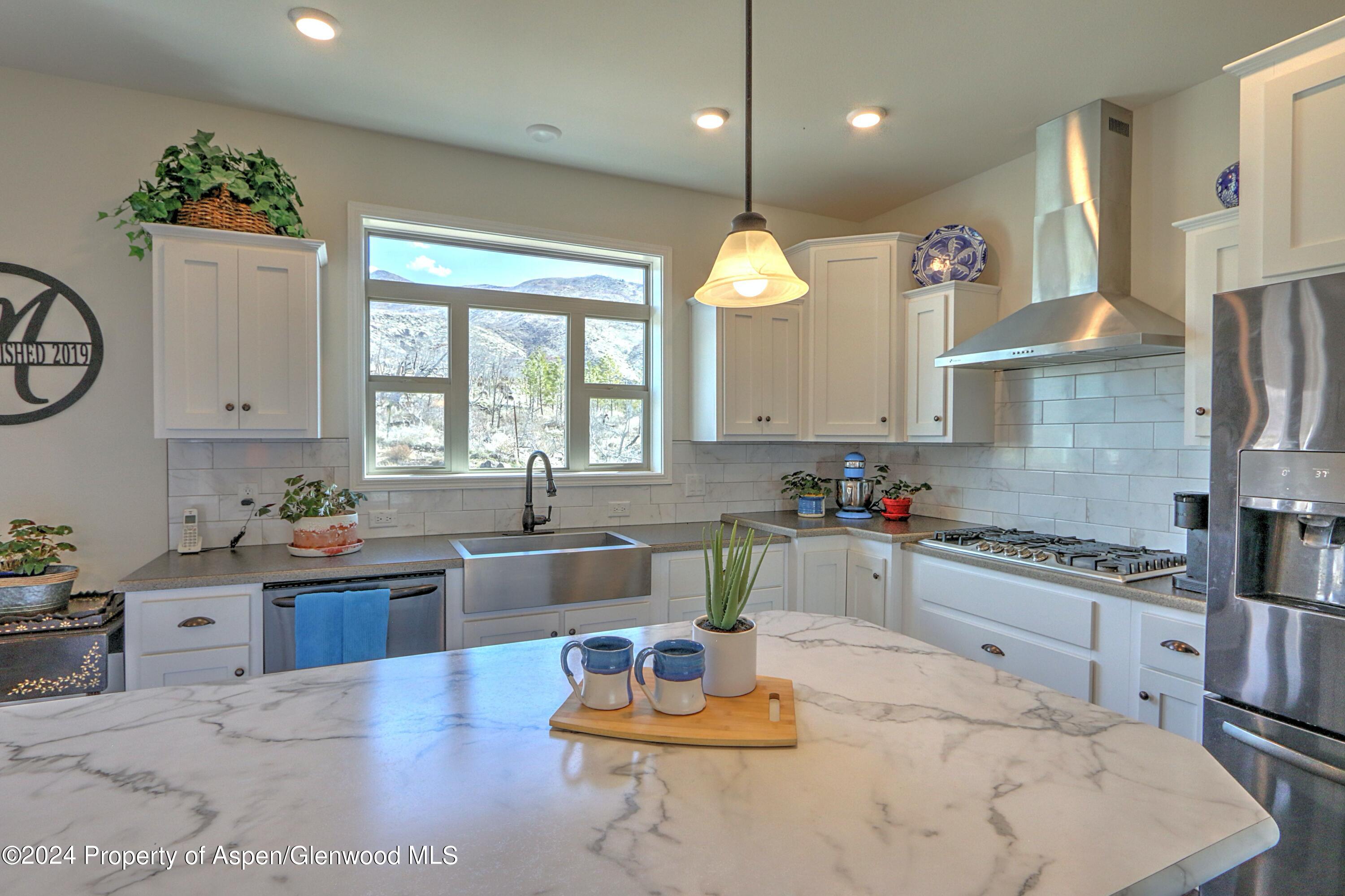 227 Lava Drive El Jebel, CO 81621 - Photo 8 of 38 a kitchen with stainless steel appliances granite countertop a sink window and cabinets