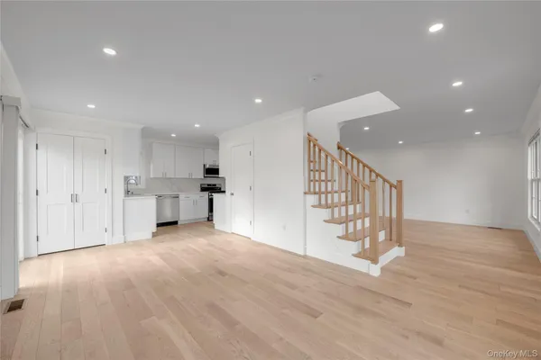 a view of a kitchen with wooden floor and staircase