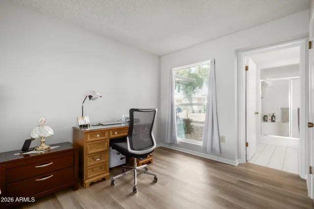 a view of a workspace with furniture and a window