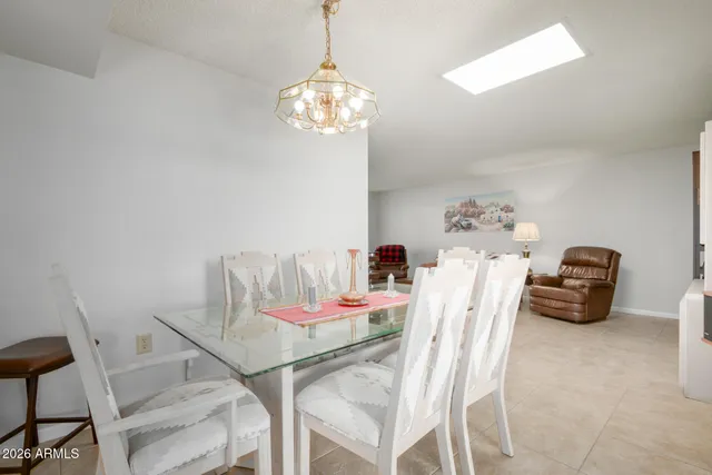 a dining room with furniture a chandelier and window