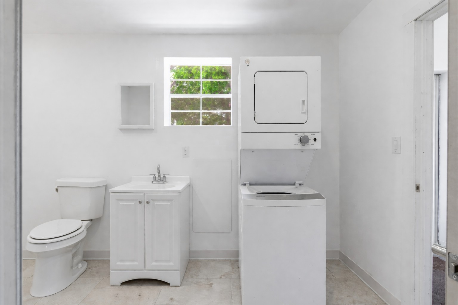 224 Old Coach Lane Elgin, TX 78621 - Photo 15 of 25 The utility room features a white stacked washer and dryer, a toilet, and a white vanity with a sink