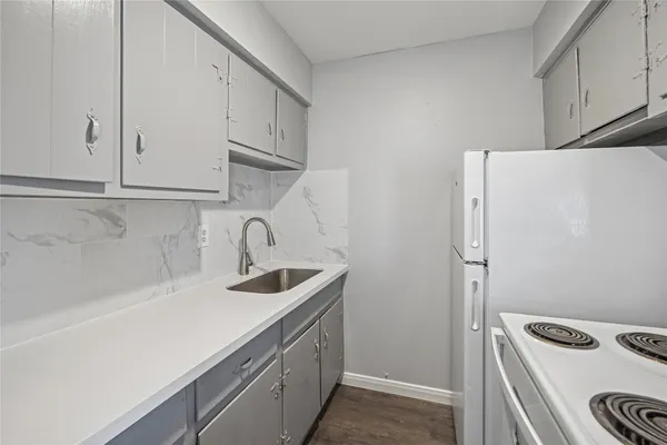 a view of a kitchen with sink and refrigerator