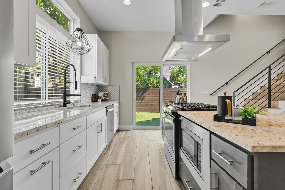 5609 Tura Lane, Unit A Austin, TX 78721 - Photo 14 of 38 a kitchen with stainless steel appliances granite countertop a sink and a stove