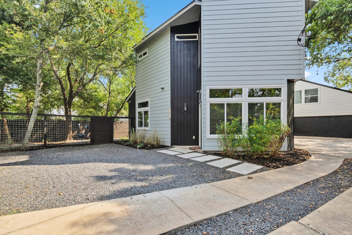 5609 Tura Lane, Unit A Austin, TX 78721 - Photo 2 of 38 a front view of a house with a yard and a garage