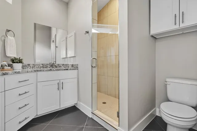 a bathroom with a granite countertop sink toilet mirror and shower