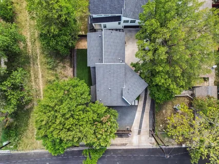 an aerial view of a house with a yard and large tree