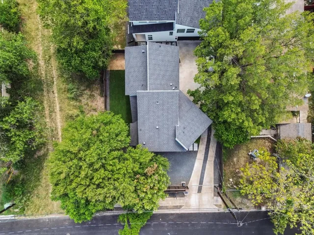 an aerial view of a house with a yard and large tree