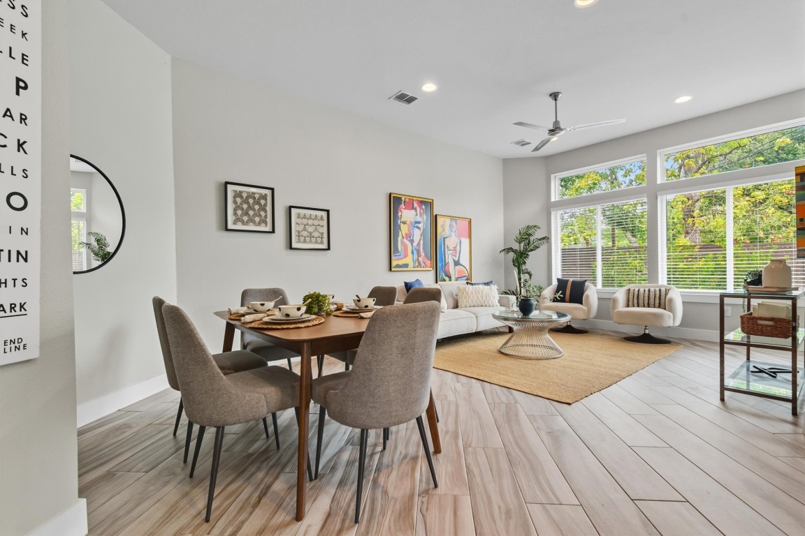 5609 Tura Lane, Unit A Austin, TX 78721 - Photo 4 of 38 a dining room with wooden floor a chandelier a glass table and chairs