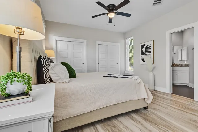 a kitchen with stainless steel appliances granite countertop a refrigerator a sink dishwasher a stove and white cabinets with wooden floor