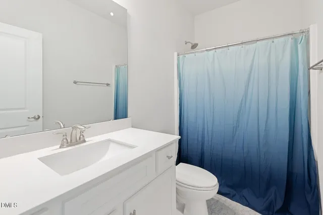 a bathroom with a toilet and a shower curtain