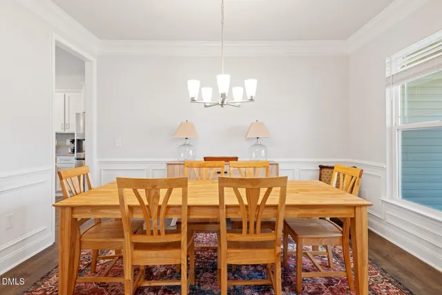 a view of a dining room with furniture wooden floor and chandelier