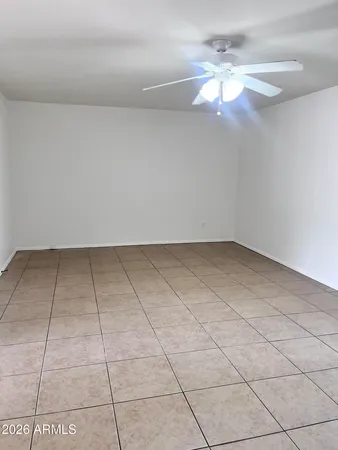 a view of an empty room with a chandelier fan