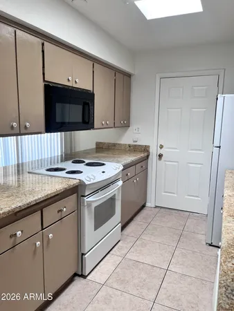 a kitchen with a stove sink and cabinets