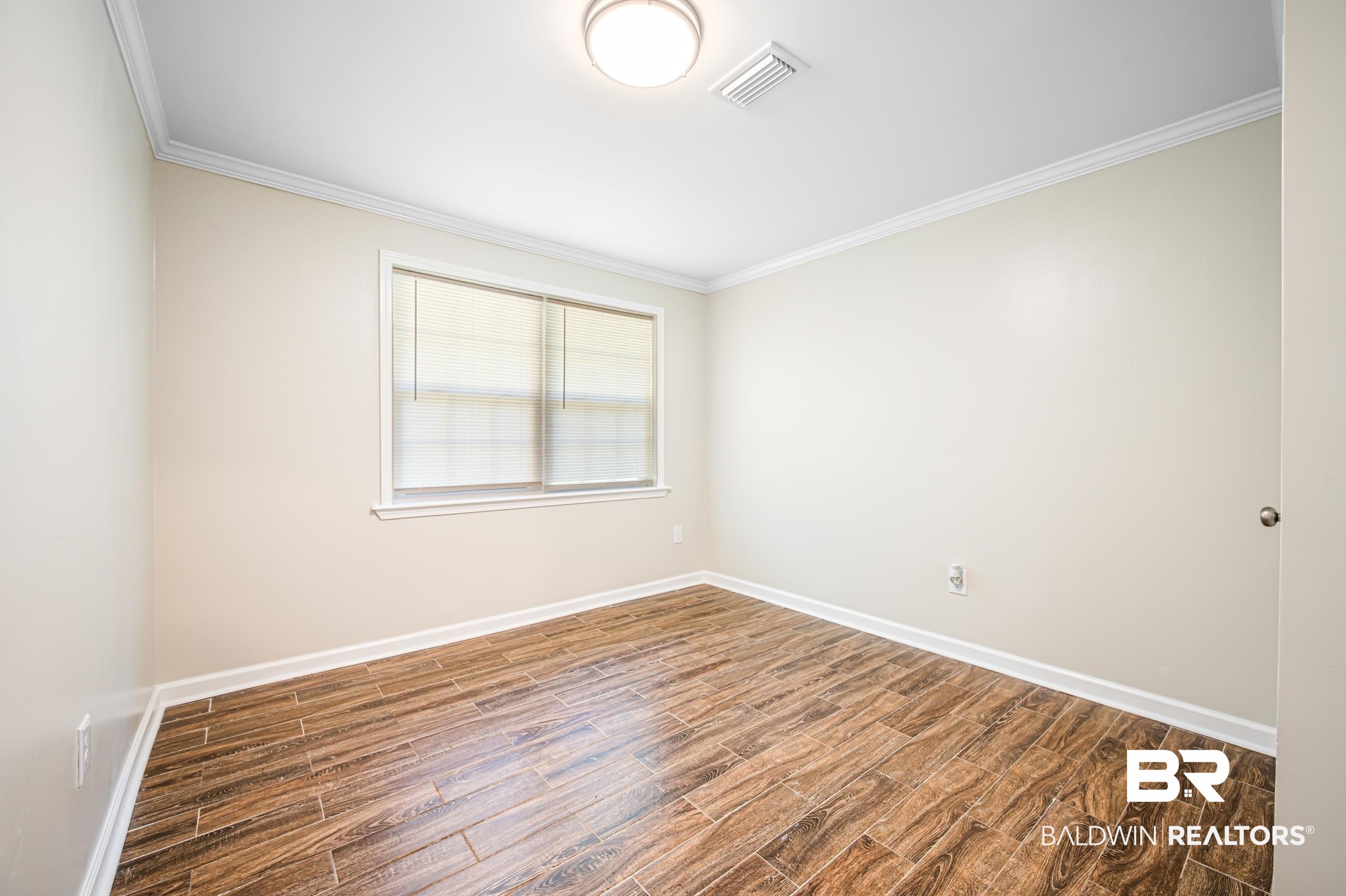 1605 Collier Avenue Bay Minette, AL 36507 - Photo 22 of 36 Unfurnished room with ornamental molding and wood finish floors