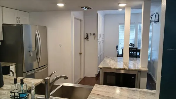 a kitchen with stainless steel appliances granite countertop a refrigerator and a sink
