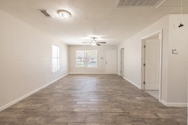 an empty room with a ceiling fan and a window