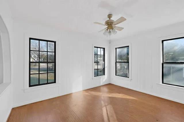 a view of an empty room with a window and cabinet