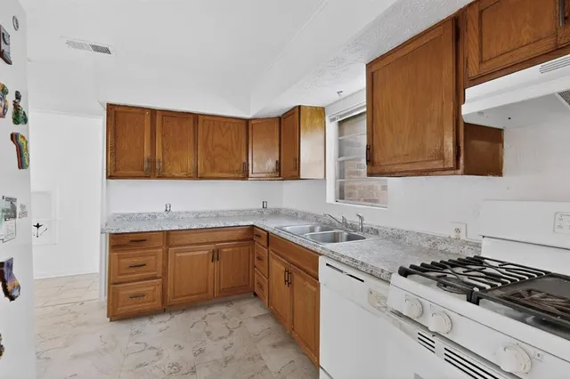 a kitchen with sink a stove and cabinets