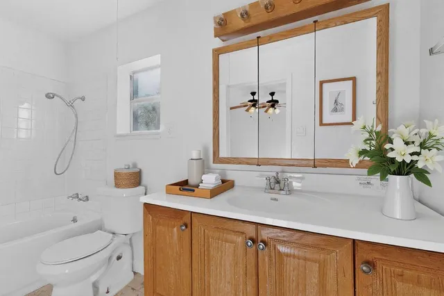 a bathroom with a granite countertop sink a toilet and shower