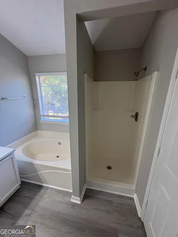 a bathroom with a bathtub a toilet and a shower