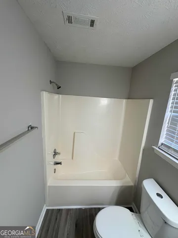 a bathroom with a toilet and a bathtub