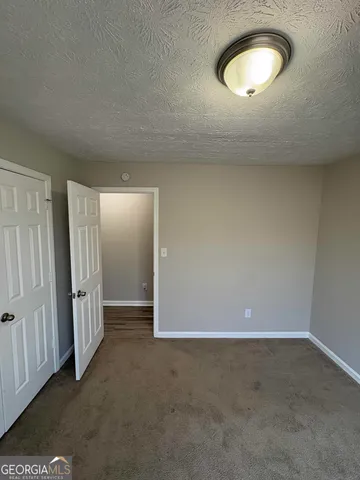 an empty room with a window and closet