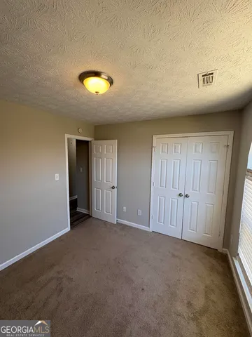 an empty room with closet and mirror