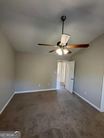 an empty room with a fan and a window