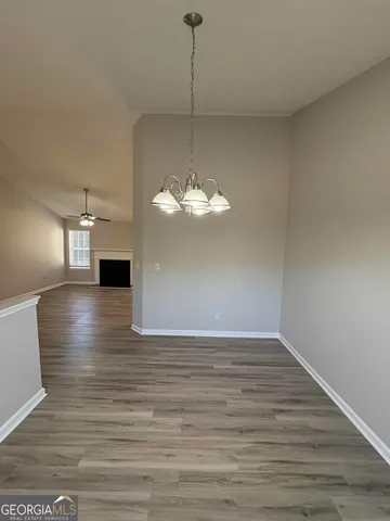 a view of a room with wooden floor staircase and a kitchen