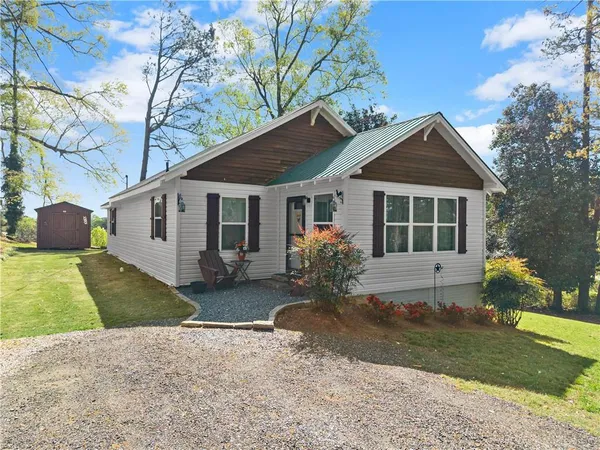 a front view of a house with a garden and yard