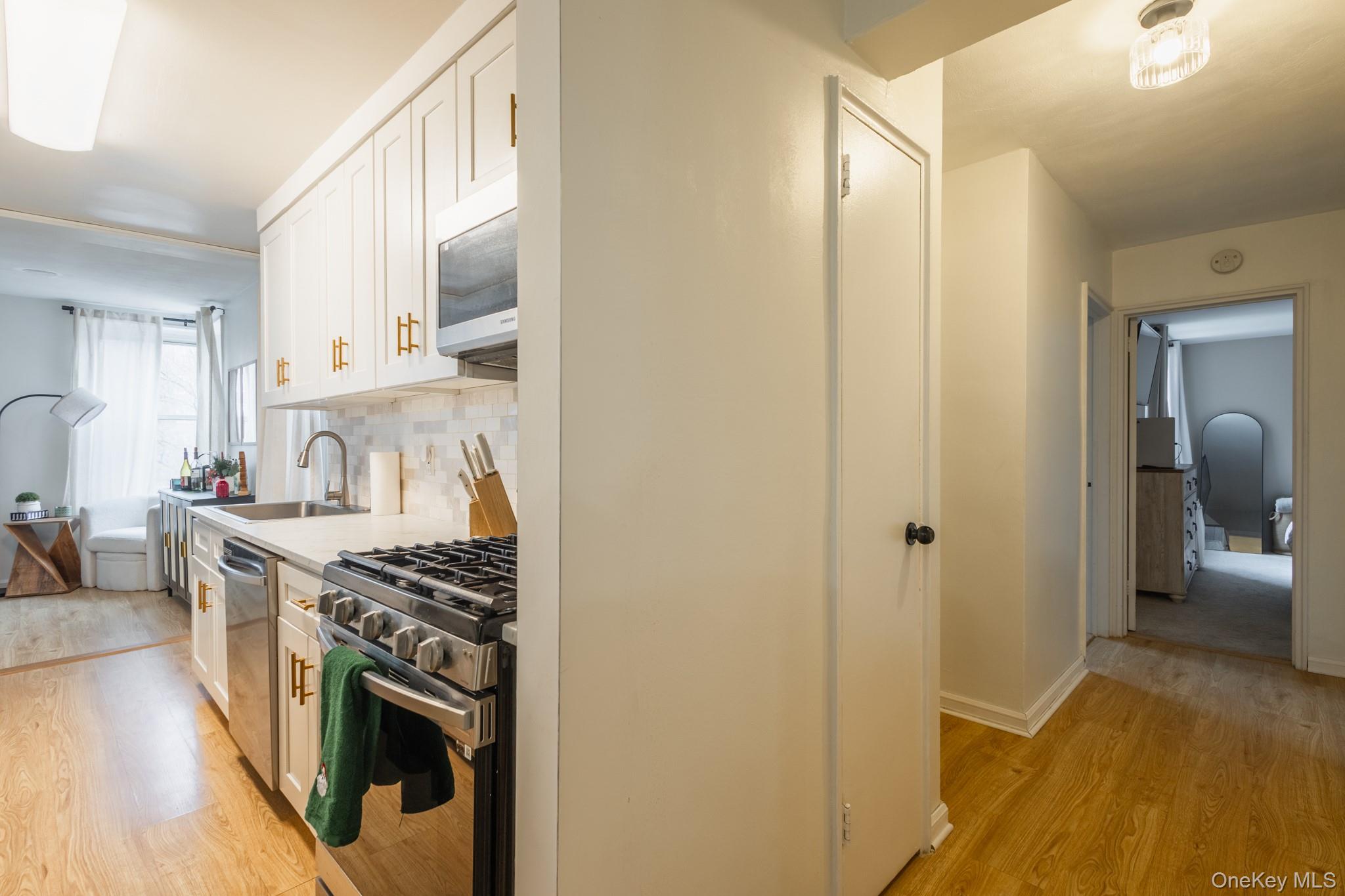 209-25 18th Avenue, Unit 3F Queens, NY 11360 - Photo 13 of 28 a kitchen with stainless steel appliances granite countertop a stove and a refrigerator