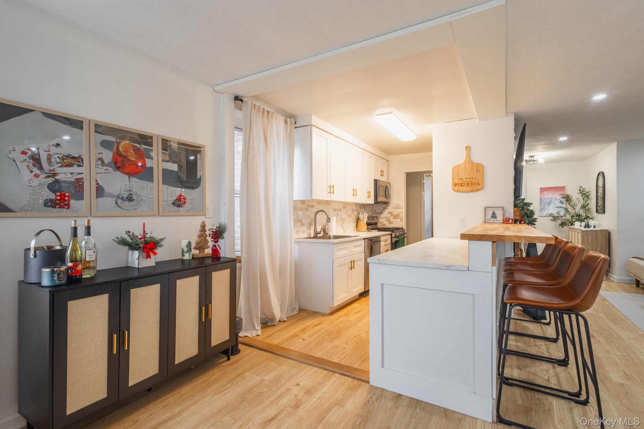 209-25 18th Avenue, Unit 3F Queens, NY 11360 - Photo 7 of 28 a kitchen that has a lot of cabinets a sink and a stove in it