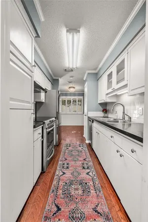 a large kitchen with stainless steel appliances granite countertop a refrigerator a stove a sink and dishwasher