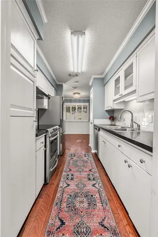 a large kitchen with stainless steel appliances granite countertop a refrigerator a stove a sink and dishwasher