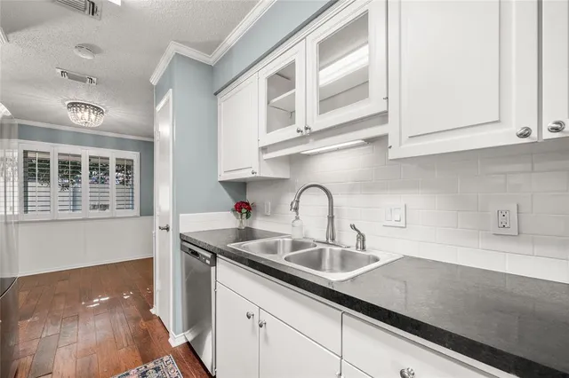 a kitchen with stainless steel appliances granite countertop a sink and white cabinets