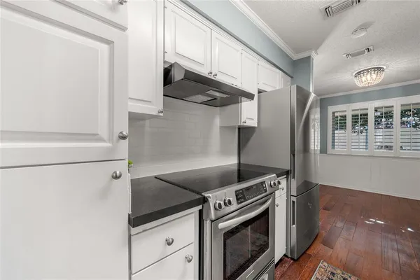 a kitchen with stainless steel appliances granite countertop a refrigerator and a stove