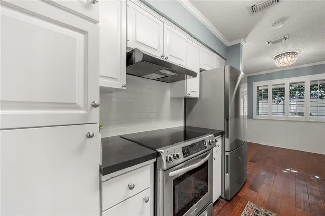 a kitchen with stainless steel appliances granite countertop a refrigerator and a stove