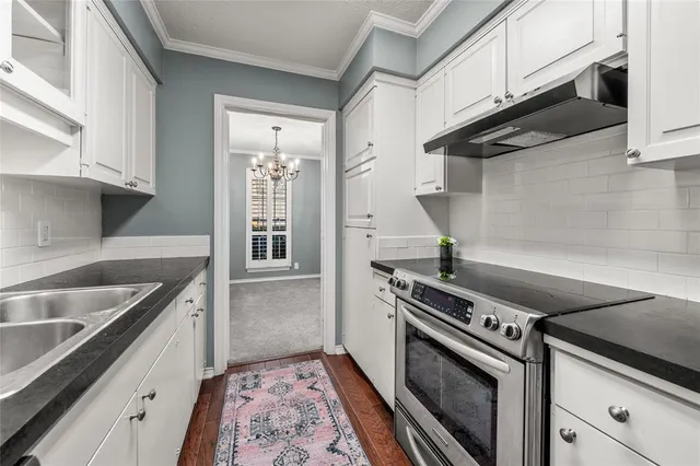 a kitchen with granite countertop a stove and a sink