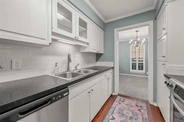a kitchen with stainless steel appliances a sink stove and cabinets